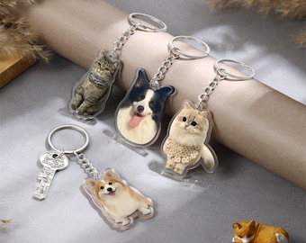 May include: Set of five keychains featuring different animal designs. The keychains are made of clear acrylic and feature images of a cat, a dog, a corgi, and two other cats. The keychains are attached to silver metal rings.