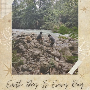 May include: A rectangular graphic print featuring a photograph of two individuals sitting on rocks by a flowing river surrounded by trees. The text reads Earth Day Is Every Day, Putting Artistry Above Efficiency, Sustainability above mass production.