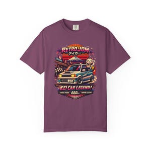 Może przedstawiać: Śliwkowy t-shirt z nadrukiem graficznym przedstawiającym biały samochód kompaktowy oraz tekst RETRO JDM, KEI CAR LEGEND, TURBO POWER, 660CC i NIPPON CLASSIC. Wzór zawiera japońskiego kota szczęścia, górę oraz tło z zachodzącym słońcem.