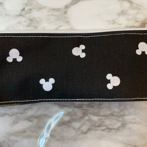 Pu&ograve; includere: Borsa nera con cerniera con un motivo di Topolino bianco.