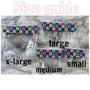 May include: Four clear, zippered pouches in x-large, large, medium, and small sizes. Each pouch has a patterned border with the letter "K" and a Mickey Mouse graphic. The words "Size guide" are above the pouches.