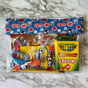 May include: A clear plastic zippered pouch with a blue fabric lining featuring a repeated pattern of red and black Spiderman characters. The pouch contains a coloring book, crayons, scissors, glue stick, and colored pencils.