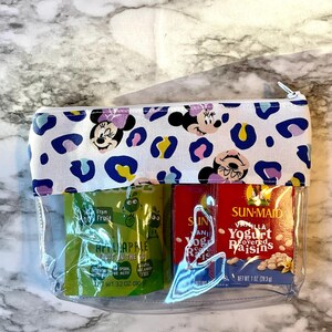 Pode incluir: Uma bolsa transparente com z&iacute;per com fundo branco e padr&atilde;o de leopardo. A bolsa tem dois compartimentos transparentes com dois pacotes de lanches dentro. Um pacote &eacute; verde e diz "From 100 Fruit Hi-Apple Fruit on the Go" e o outro pacote &eacute; vermelho e diz "Sun-Maid Vanilla Yogurt Covered Raisins".