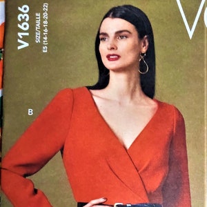 May include: A rust-colored wrap top with long sleeves and a peplum design, cinched at the waist with a black belt. The top features a V-neckline and is part of a sewing pattern, size E5 (14-16-18-20-22).