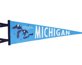 May include: A blue pennant with a white outline and the text "MICHIGAN" in white. The pennant also features a blue silhouette of the Great Lakes with the text "THE GREAT LAKES STATE" in white.