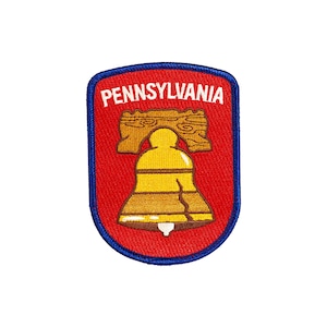 Puede incluir: Parche bordado con la Campana de la Libertad, un símbolo de Pensilvania. El parche tiene un fondo rojo con un borde azul y la palabra "PENNSYLVANIA" en blanco. La campana es amarilla y marrón.