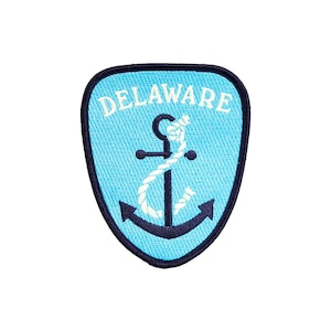 May include: A blue and white embroidered patch with a navy blue anchor and the word "DELAWARE" in white lettering.