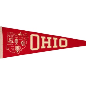 May include: Red felt pennant with a white outline of the state of Ohio and the word "OHIO" in white letters. The outline of Ohio includes a map of the state with various landmarks and the words "Lake Erie" and "Ohio Turnpike".