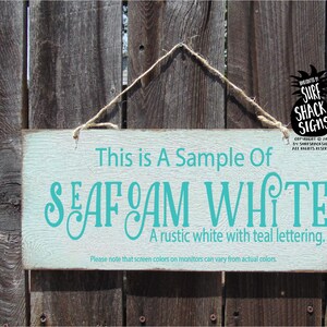 a sign hanging on a wooden fence that says, this is a sample of sea