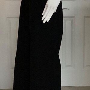Puede incluir: Pantalones negros de pierna ancha con cintura alta y silueta ajustada.