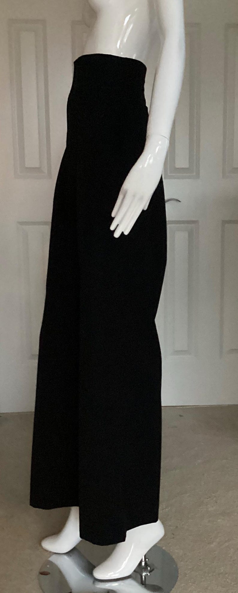 Puede incluir: Pantalones negros de pierna ancha con cintura alta y silueta ajustada.