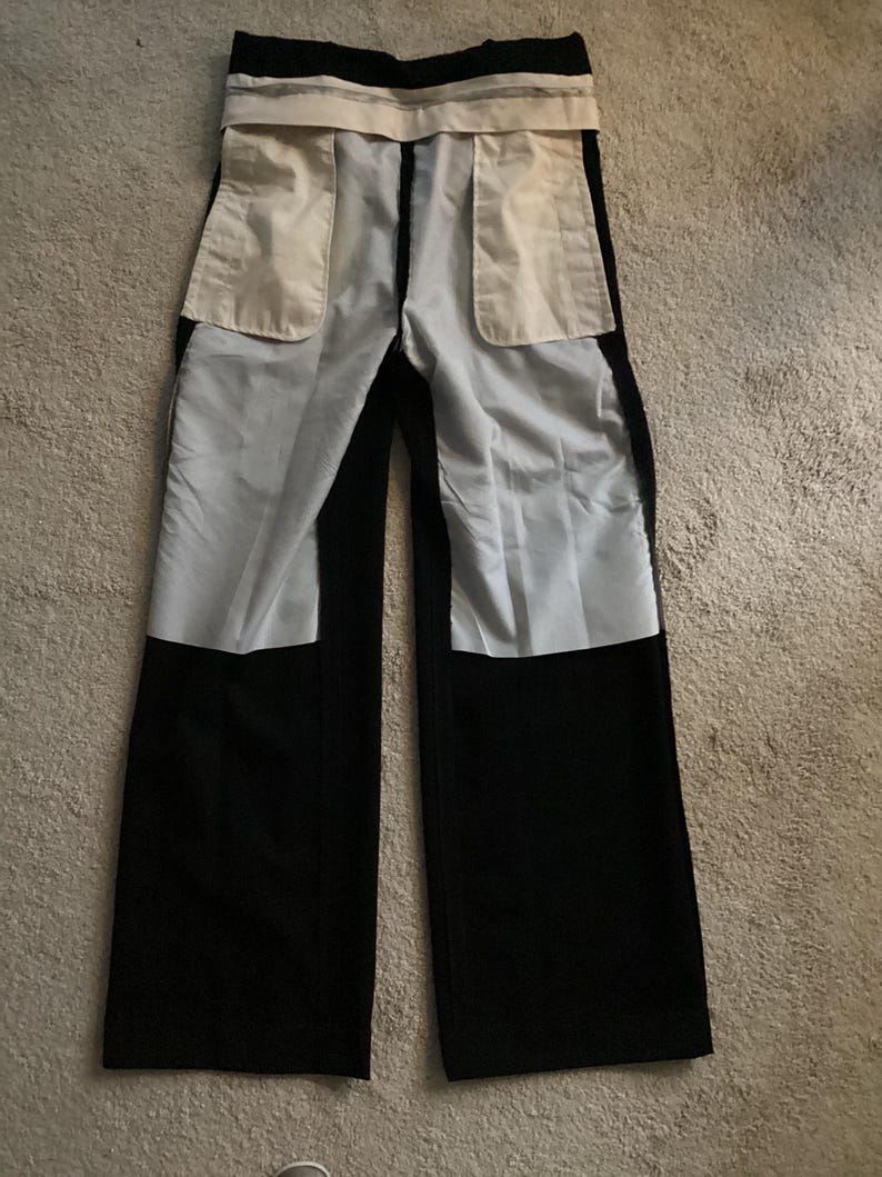 Puede incluir: Pantal&oacute;n negro con una cintura blanca y dos grandes bolsillos blancos en la parte posterior.