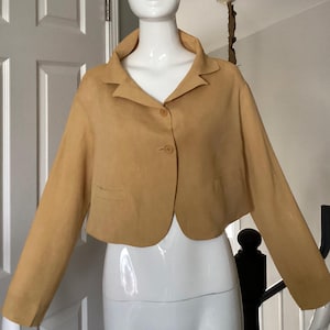 Chaqueta corta vintage Romeo Gigli de 1992, de seda dorada y nailon, talla J9 (USA8), con abertura en el bajo de la espalda, sin forro, mangas largas y bolsillos funcionales.