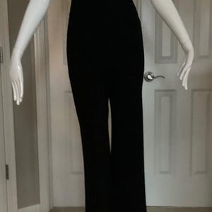 Puede incluir: Pantal&oacute;n negro de pierna ancha en un maniqu&iacute; blanco. El pantal&oacute;n tiene cintura alta y pierna recta.