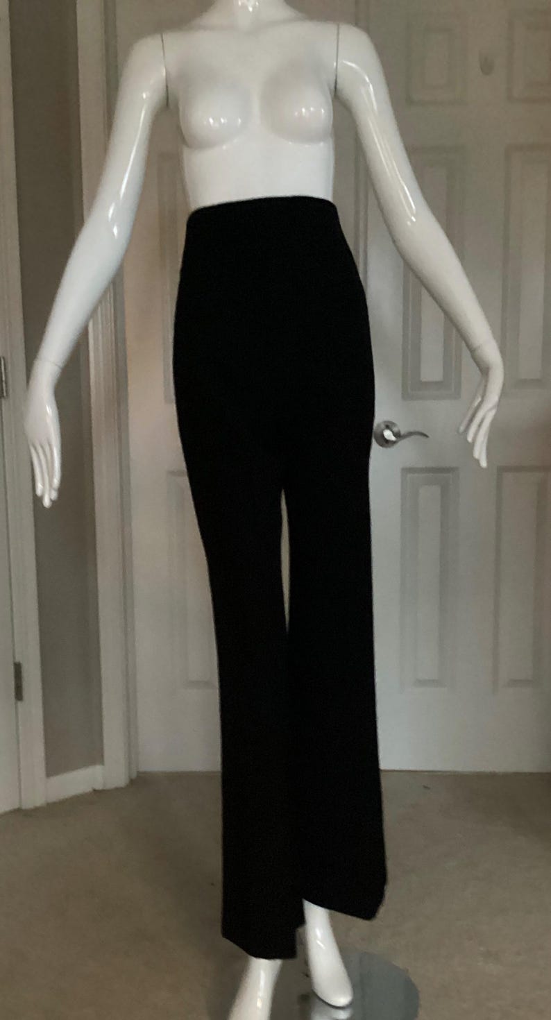 Puede incluir: Pantal&oacute;n negro de pierna ancha en un maniqu&iacute; blanco. El pantal&oacute;n tiene cintura alta y pierna recta.
