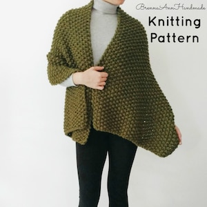 May include: A green knitted scarf with a textured stitch pattern. The scarf is draped over a person's shoulders and is styled with a grey turtleneck sweater and black pants. The text "Knitting Pattern" is visible in the top right corner of the image.