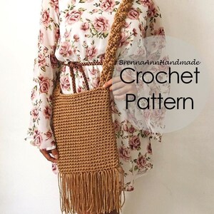 Puede incluir: Un bolso de crochet marrón con flecos largos. El bolso se lleva sobre el hombro de una persona que lleva un vestido floral. El texto "BrennaAnnHandmade Crochet Pattern" es visible en la imagen.