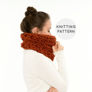 Puede incluir: Primer plano de una mujer con una bufanda de cuello de tortuga de punto grueso de color naranja quemado. La bufanda está hecha con un hilo grueso y tiene un patrón de punto de cable. El texto "Knitting Pattern" es visible en un círculo blanco en el lado derecho de la imagen.