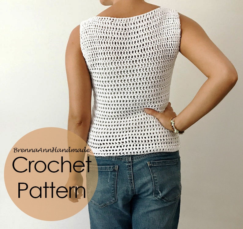 K&ouml;nnte beinhalten: Wei&szlig;es H&auml;keltop mit einem lockeren, offenen Muster. Das Top ist &auml;rmellos und hat einen runden Ausschnitt. Das Model tr&auml;gt das Top zu einer blauen Jeans. Der Text "BrennaAnnHandmade Crochet Pattern" ist in der linken unteren Ecke des Bildes zu sehen.