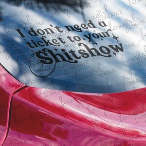 以下が含まれることがあります： 「I don't need a ticket to your shitshow」というテキストがスタイリッシュなフォントで書かれた黒いビニールデカール。デカールは車の窓に貼られており、下にはピンク色の車体が見えます。