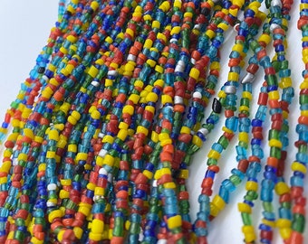 May include: A long strand of colorful glass beads in shades of red, yellow, blue, green, and white. The beads are small and uniform in size, creating a vibrant and textured look.
