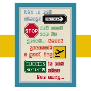 May include: A framed cross-stitch design with a beige background and colorful road signs. The text reads: "Life is not always one way and rest can be great... treat yourself to a good day. Success is not that far away..."