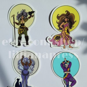Puede incluir: Cuatro pegatinas coloridas con ilustraciones de mujeres en diferentes poses. La primera pegatina muestra a una mujer con un cuervo en el hombro sosteniendo un bastón. La segunda pegatina muestra a una mujer con el pelo largo y castaño vistiendo un vestido de girasol. La tercera pegatina muestra a una mujer con el pelo largo y azul y un gato. La cuarta pegatina muestra a una mujer con el pelo arcoíris en una postura de yoga.