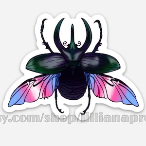 Puede incluir: Una pegatina con un escarabajo estilizado con grandes cuernos y alas. El cuerpo del escarabajo es oscuro, con detalles verdes y negros. Las alas muestran colores rosa, azul y blanco. La pegatina tiene el texto "etsy.com/shop/lillianapress".
