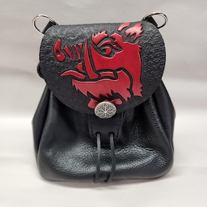 May include: Black leather pouch with a red boar design on the flap. The pouch has a drawstring closure and a decorative silver-colored button. The bag has two silver rings at the top.