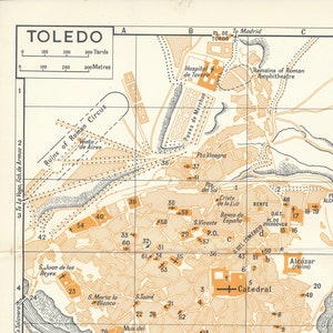 May include: A vintage map of Toledo, Spain, with a grid overlay and numbered points of interest. The map highlights the Alcazar, Cathedral, and other historical landmarks. The map is printed on a cream-colored background with brown and black lines.