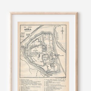 May include: A black and white map of Agra, India, showing the layout of the city and its surrounding area. The map includes a key with numbered locations and their names, such as the Taj Mahal, the Red Fort, and the Jama Masjid. The map is titled "The Fort Agra".