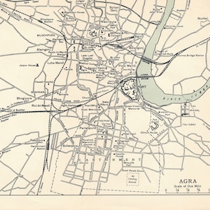 May include: A vintage map of Agra, India, in black and white. The map details streets, landmarks, and the river. The scale is one mile. The text "AGRA" is at the bottom right.