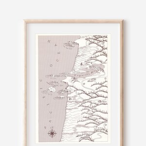 Peut inclure: Un dessin au trait noir et blanc d'un paysage côtier avec une rose des vents et les mots "PACIFIC OCEAN" imprimés sur le côté. Le dessin est encadré dans un cadre en bois clair.