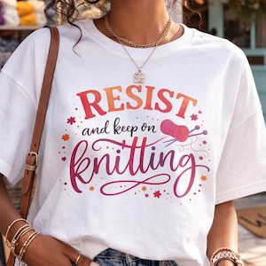 May include: A woman in a white t-shirt with the text "RESIST and keep on knitting". The image shows a yarn shop in the background. The woman is holding a coffee cup.