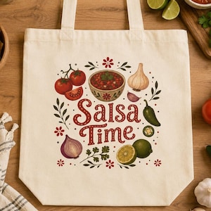 Puede incluir: Bolso tote color crema con un diseño colorido de "Salsa Time". El diseño incluye un cuenco de salsa, tomates, cebolla, lima, ajo y un jalapeño. La bolsa tiene dos asas.
