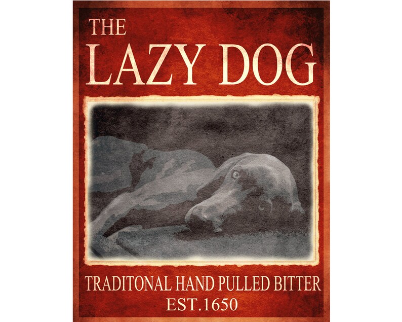 May include: A vintage-style sign with a red background and white text that reads "The Lazy Dog" with a black and white image of a dog sleeping in the center. The text below the image reads "Traditional Hand Pulled Bitter Est. 1650".
