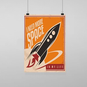 Puede incluir: Un póster de estilo retro con fondo naranja y un cohete negro con una llama roja. El texto del póster dice "Necesito más espacio en mi vida."