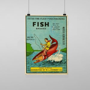 Puede incluir: Etiqueta vintage para "Fish Brand" Extra Fine Flash Firecrackers. Una ilustración de dibujos animados de un hombre montando un pez que salta del agua. La etiqueta incluye el texto "Do Not Hold In Hand After Lighting" y "80/20 Reports". Hecho en China y distribuido por W. L. Stewart Co.