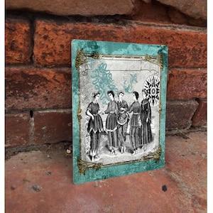 Puede incluir: Una ilustración de estilo vintage de cinco mujeres de pie juntas en un grupo. Llevan vestidos largos y tienen el pelo recogido hacia atrás. La ilustración está sobre un fondo turquesa con un marco dorado y un diseño de brújula.