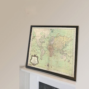 Puede incluir: Un mapa del mundo vintage enmarcado con fondo verde y líneas marrones. El mapa está titulado "Carte Generale De La Grande Terre" y data de 1750.