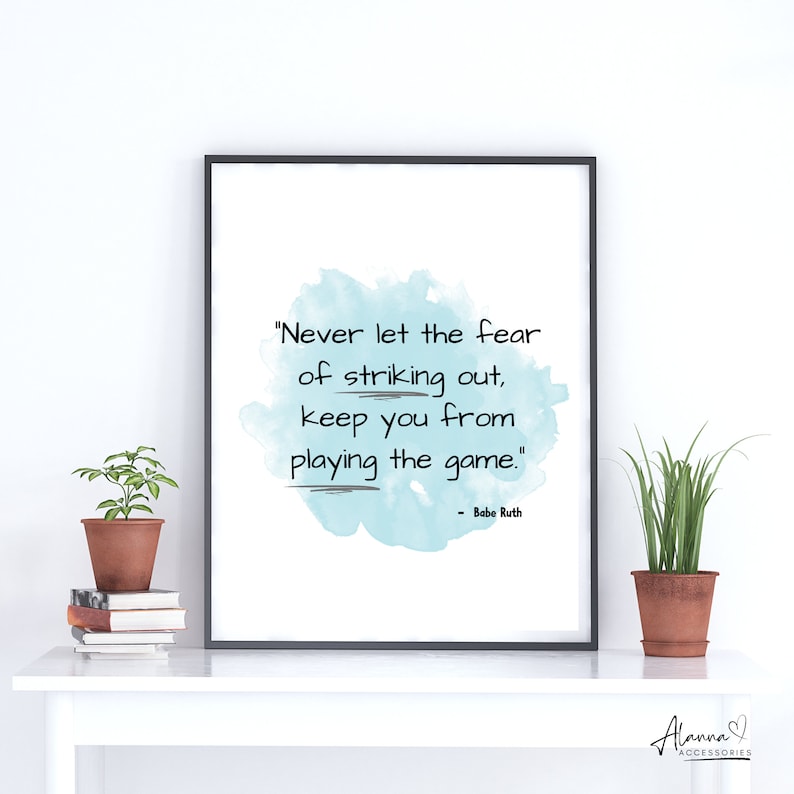 May include: A motivational quote by Babe Ruth printed on a light blue watercolour background. The quote reads "Never let the fear of striking out, keep you from playing the game."