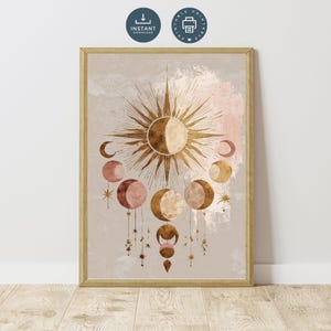 Può includere: Una stampa artistica incorniciata con un design celeste. L'opera d'arte presenta un'esplosione solare dorata, lune crescenti e fasi lunari in tonalità oro, rosa e marrone. La stampa ha uno sfondo neutro con effetto acquerello.