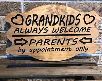 May include: Wooden sign with the text "Grandkids Always Welcome" and "Parents by appointment only". The sign has a heart shape on each side of the word "Grandkids".