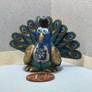 Peacock miniature made with polymer clay caned tail feathers. Gilded with metalic powders.