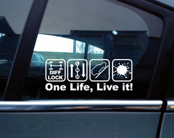 May include: A white vinyl decal applied to a car window featuring four square icons representing a differential lock, a gear shift pattern, a vehicle on an incline, and a paint splatter, with the text One Life, Live it! below.