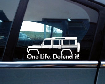 May include: A white vinyl decal applied to a car window, featuring the side profile silhouette of a four-door off-road vehicle with a spare tire on the back. Below the vehicle graphic, the text reads, One Life. Defend it!
