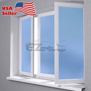 May include: A white window with two panes of frosted glass. The window is open and the glass is a light blue color.