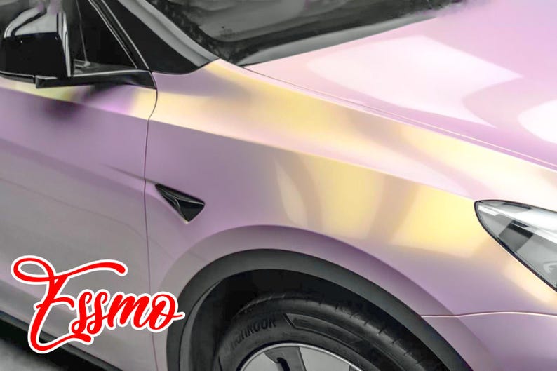 May include: A close-up of a pink and yellow car with a black side mirror and a black wheel. The car has a custom paint job with a gradient effect. The word "Essmo" is written in red cursive on the side of the car.