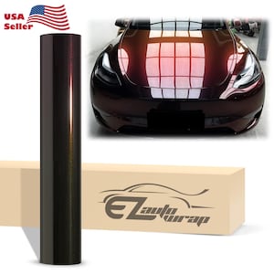 May include: A cylindrical roll of dark metallic burgundy automotive vinyl wrap standing vertically next to a light-colored box featuring the text EZautowrap and a graphic of a car, with a photo of a car with the same color wrap above.