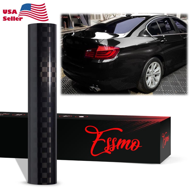 May include: A roll of black carbon fiber vinyl wrap featuring a checkered pattern, displayed next to a black box with the red text Essmo. The wrap is shown applied to the rear quarter panel and trunk of a black sedan with silver wheels.